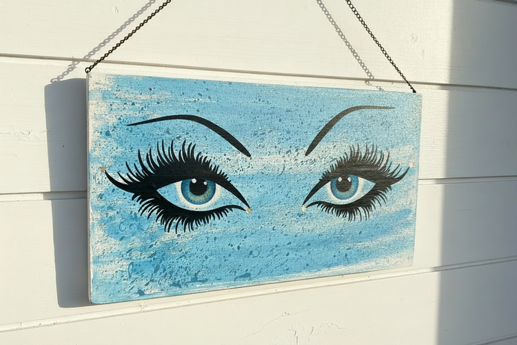 One-of-a-kind hand-painted eyes art on reclaimed wood, hung with chain on white shiplap wall