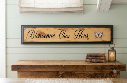Handcrafted Bienvenue Chez Nous wood sign with butterfly on natural wood and black frame, hung above a rustic wood shelf
