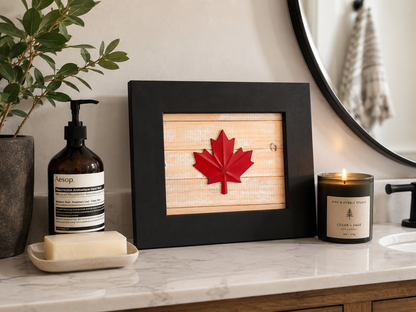 Reclaimed wood Canadian maple leaf wall art with black frame, styled on a marble bathroom vanity alongside an Aesop hand wash and a Pine and Pebble Studio Cedar and Sage soy candle