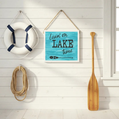 Livin on Lake Time sign hanging in sunny boathouse with vintage paddle life preserver and summer cottage atmosphere